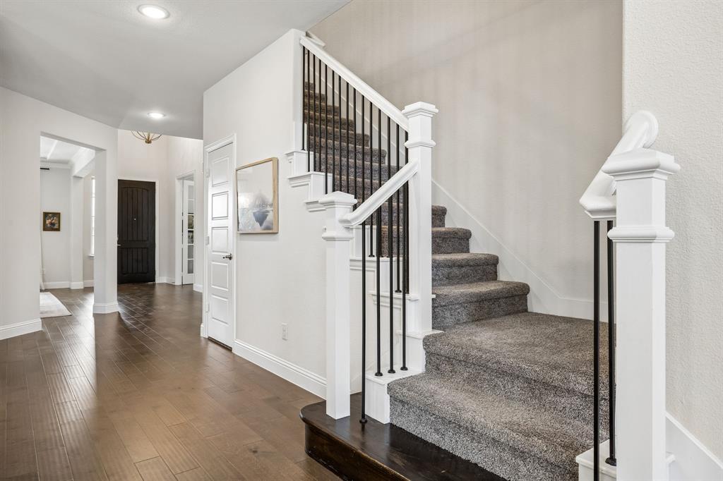 Stairway with hardwood / wood-style flooring and recessed lighting