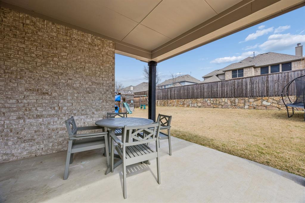 Fenced backyard with a patio, a trampoline, and outdoor dining space
