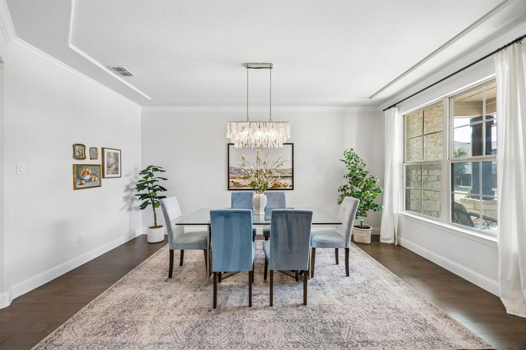 Dining space featuring dark wood finished floors, a chandelier, and ornamental molding
