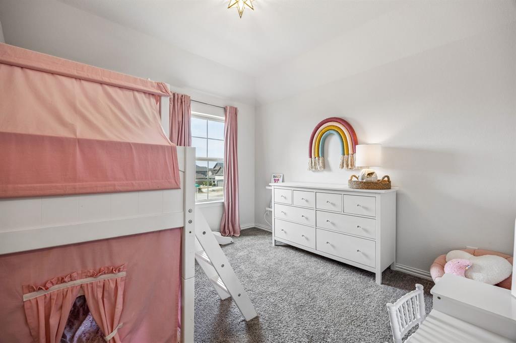Bedroom featuring dark carpet and baseboards
