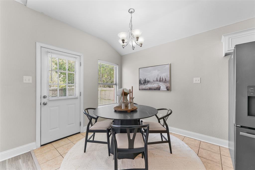 Virtually staged.Dining room featuring lofted ceiling, a chandelier, and light tile patterned floors