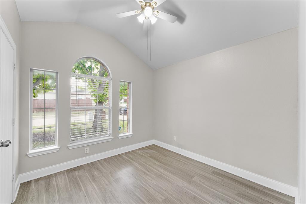 Unfurnished room with ceiling fan, light wood-style flooring, and vaulted ceiling