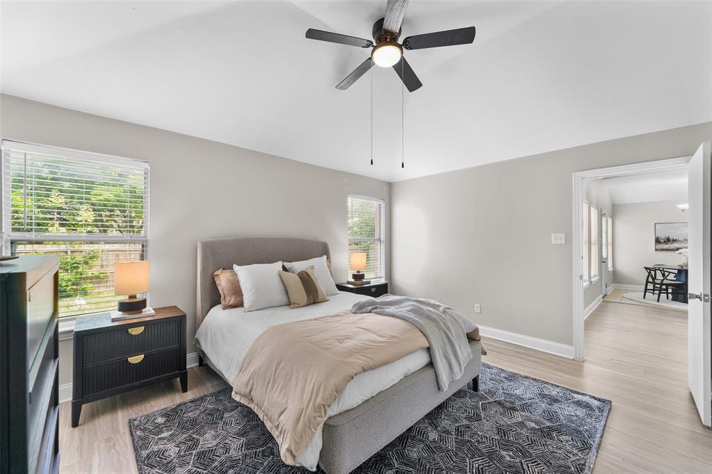 Bedroom with vaulted ceiling, ceiling fan, and light wood finished floors