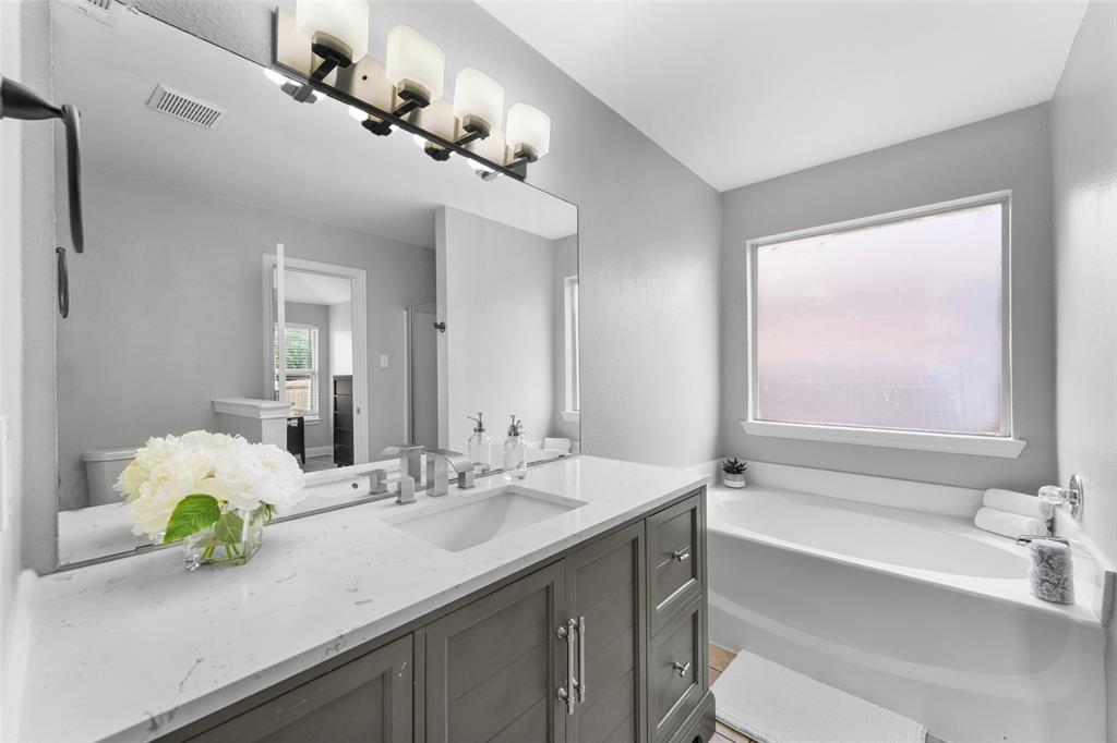 Bathroom featuring vanity and a bath