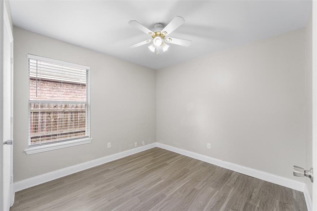 Spare room with light wood finished floors and ceiling fan