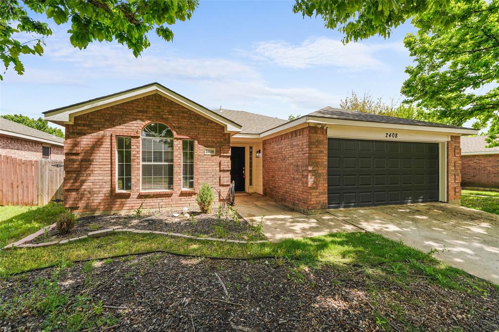 Ranch-style home with a garage, driveway, and brick siding
