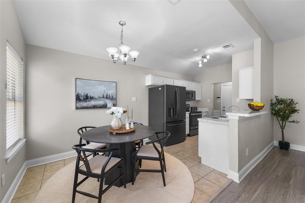 Virutally staged. Dining space featuring light tile patterned floors, suspended lighting, and lofted ceiling