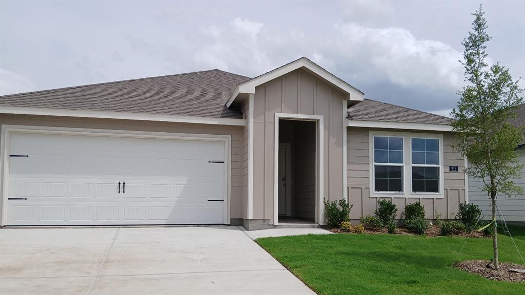 Contemporary single-story residence featuring a two-car garage, beige siding with vertical accents, and a covered entry