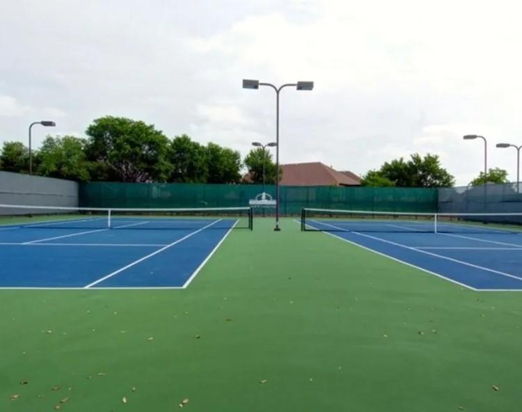Two tennis courts featuring blue and green surfacing
