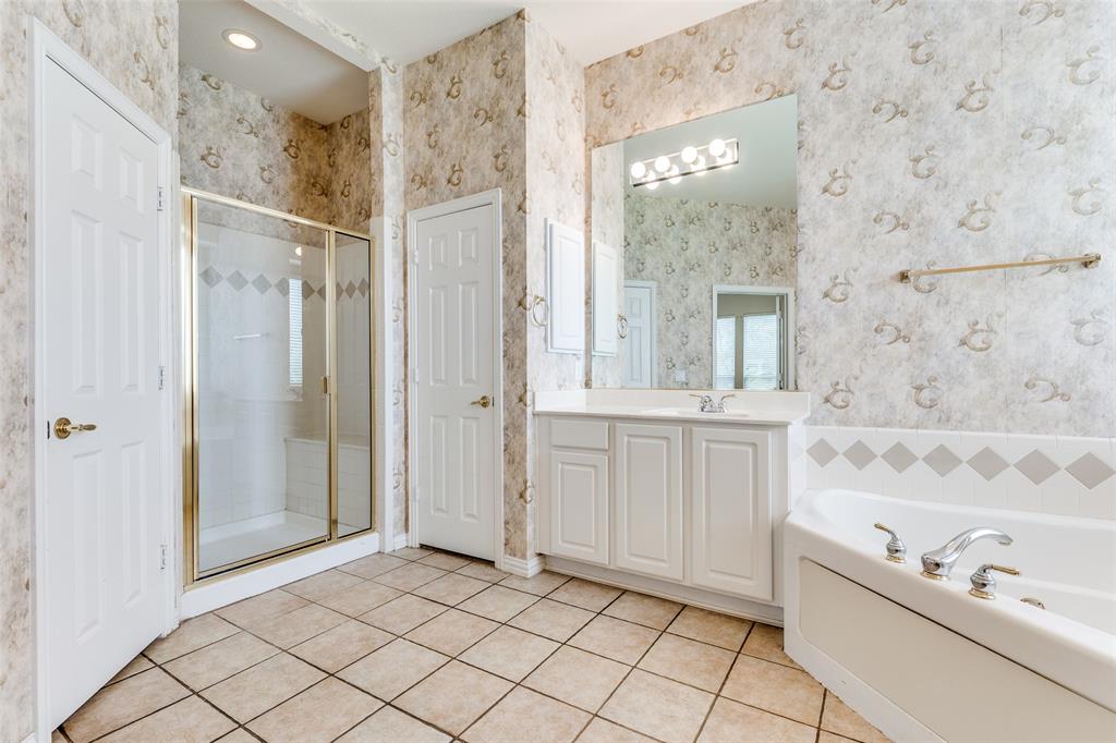 Primary bath featuring a walk-in shower, vanity, a bath, and light tile patterned flooring