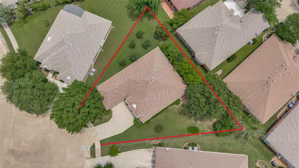 Expansive lot with mature trees, manicured lawns, and a private driveway