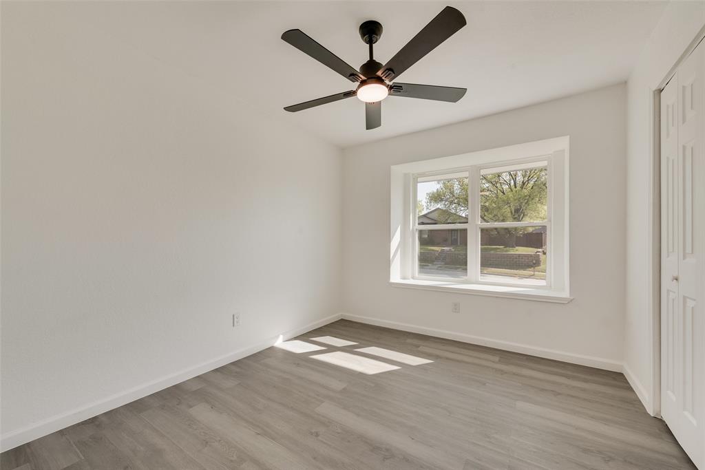 Unfurnished bedroom featuring a closet, light wood-style flooring, and a ceiling fan