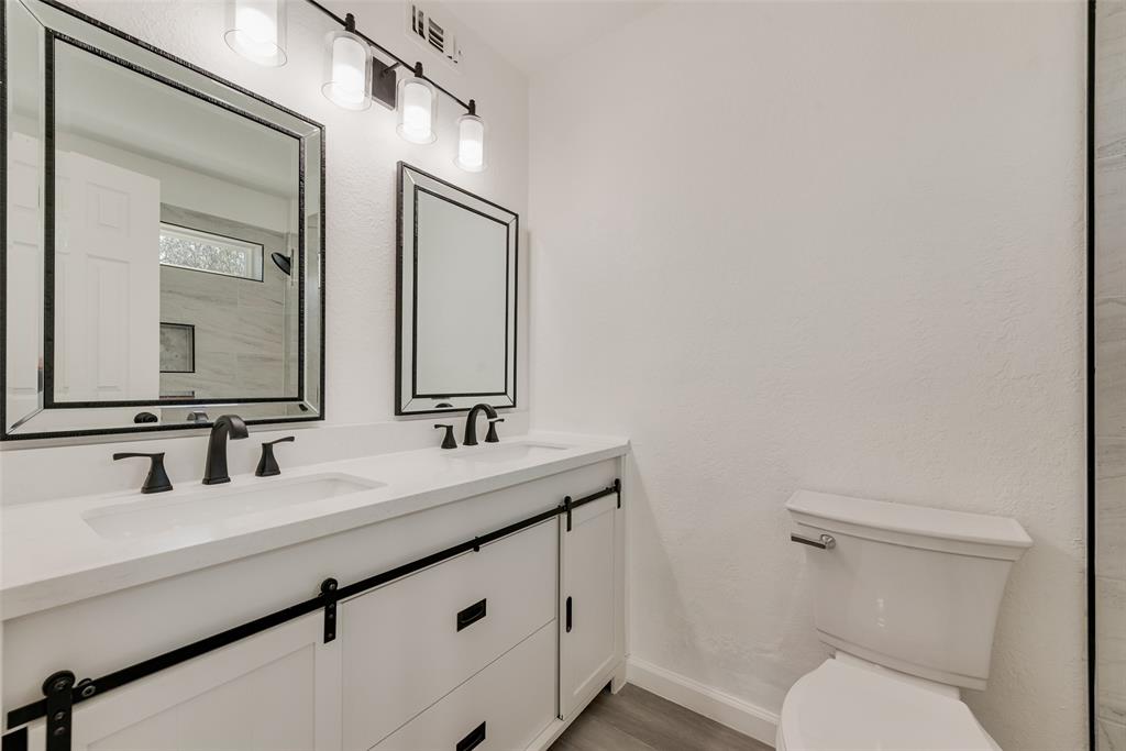 Bathroom featuring double vanity and light wood-style flooring