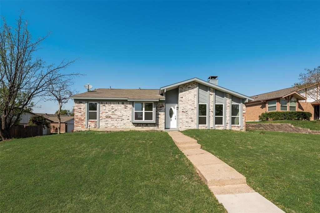 Mid-century home with brick siding, a chimney, and a front yard Mid-century home with brick siding, a chimney, and a front yard