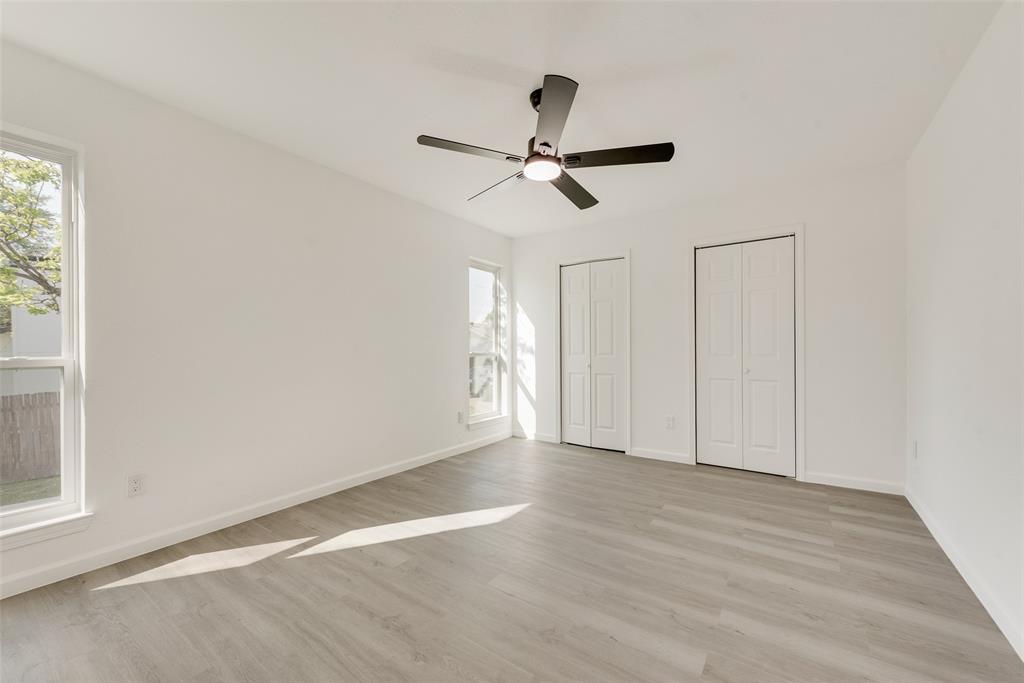Unfurnished bedroom with multiple closets, light wood-style flooring, and ceiling fan