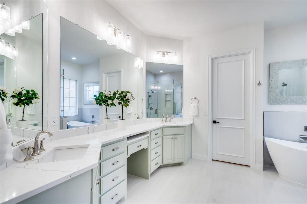 Spa-like primary bathroom with oversized vanity and makeup desk.
