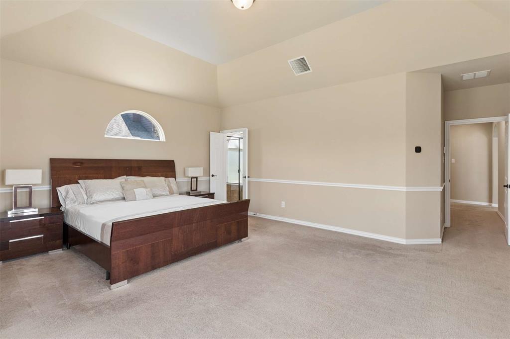 Bedroom featuring light carpet and vaulted ceiling