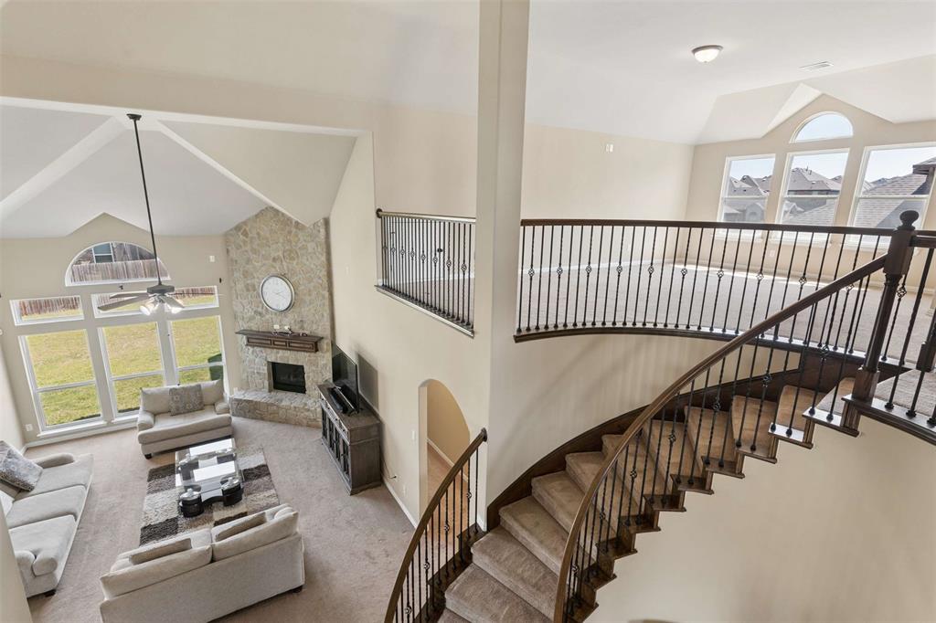 Living room featuring lofted ceiling, a fireplace, carpet, and ceiling fan