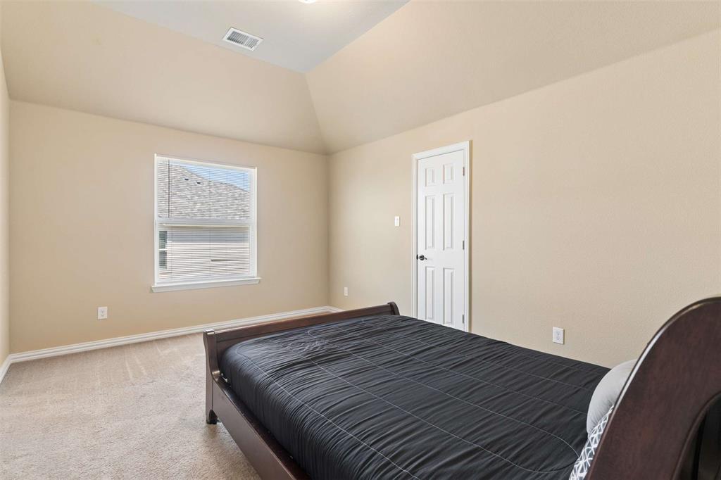 Bedroom featuring light carpet and lofted ceiling
