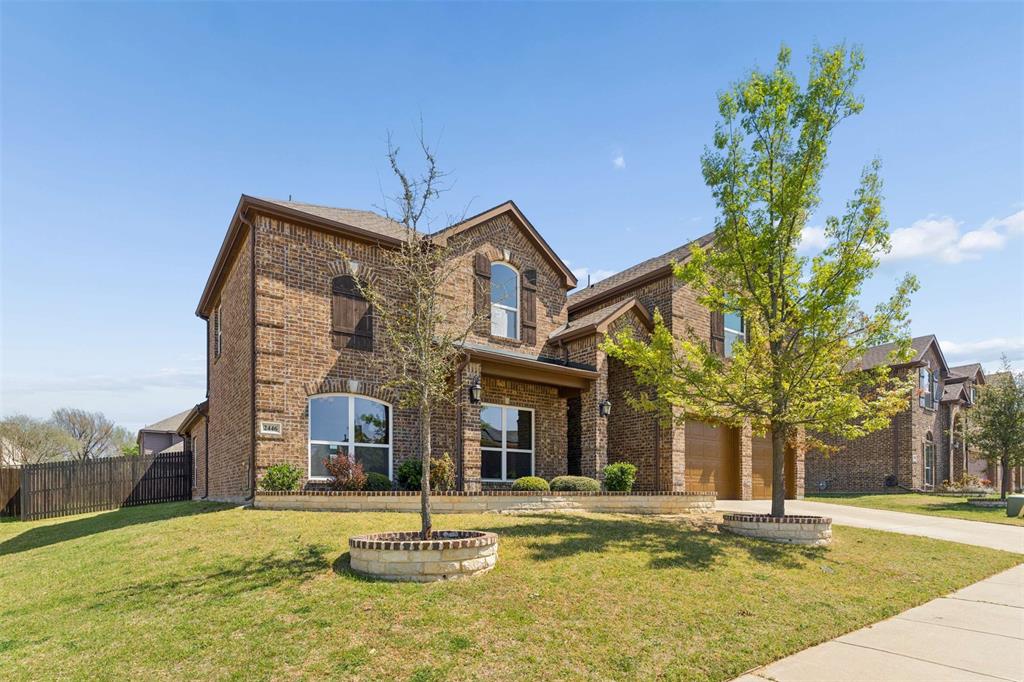 Traditional home with brick siding, driveway, and a garage