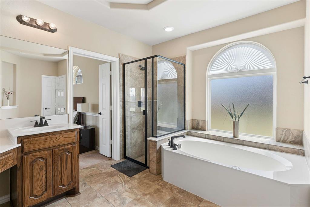 Bathroom featuring a shower stall, vanity, and a bath