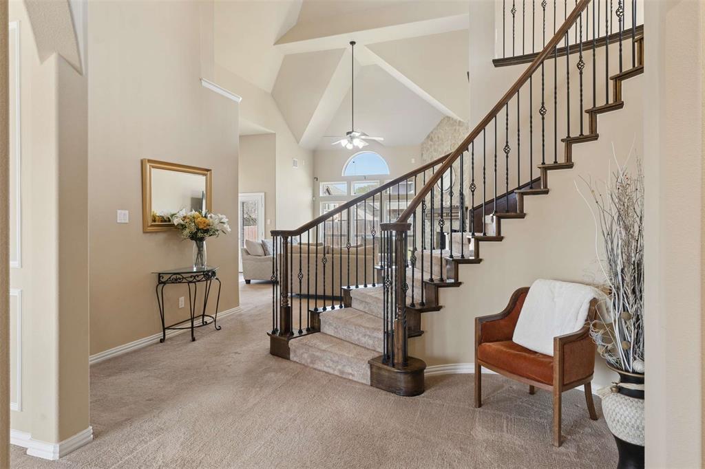 Stairway featuring a high ceiling, carpet, and ceiling fan