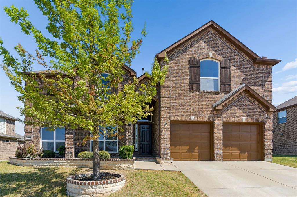 View of front of home featuring brick siding, a garage, concrete driveway, and a front yard