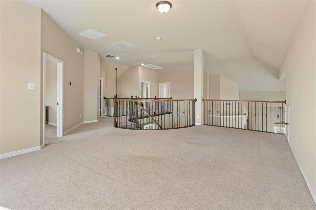 Unfurnished room with light colored carpet and vaulted ceiling