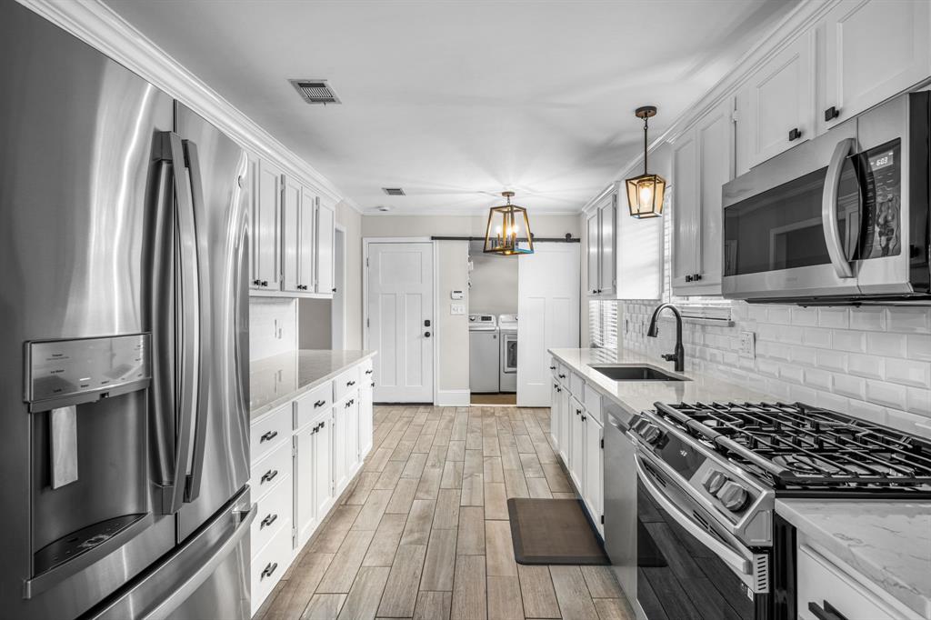 The updated kitchen features stainless steel appliances including a gas range.