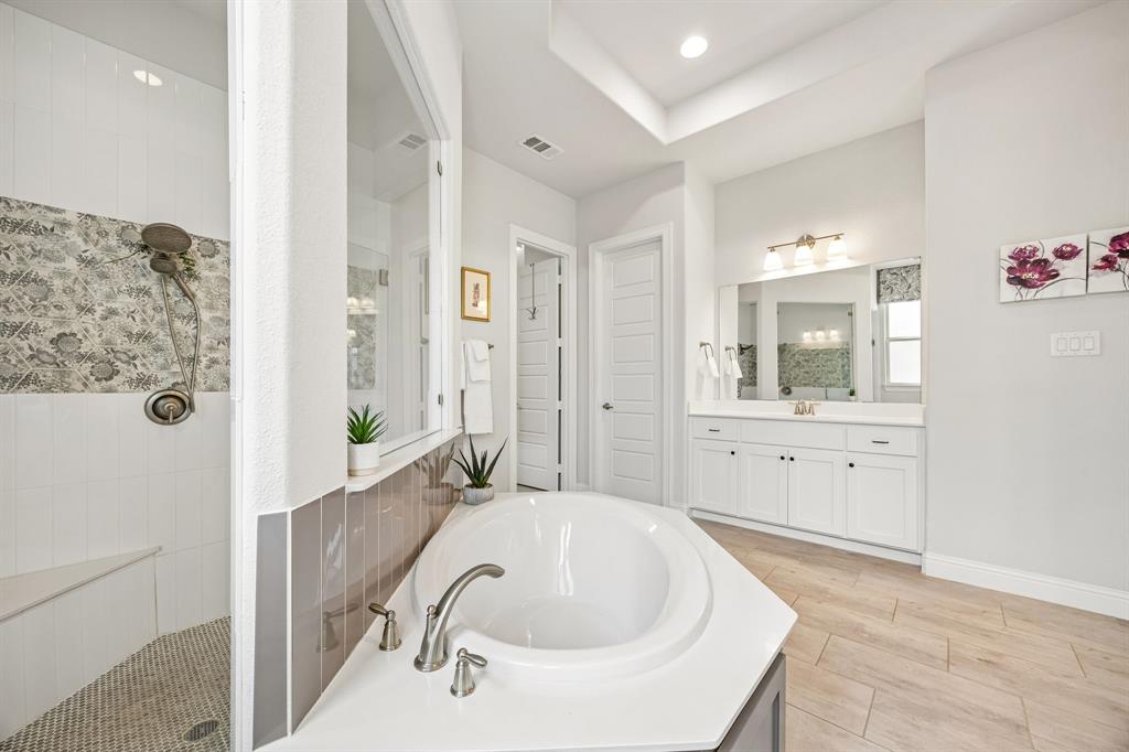 This spacious primary ensuite offers dual vanities set across the space from one another.