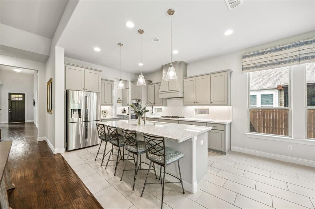 Spectacular chef's kitchen, designed for both high-end culinary creation and effortless entertaining. A bright and airy space centers around a massive quartz island that comfortably seats four, making it the ultimate gathering hub for family and guests.