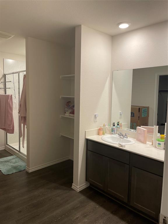 Full bathroom with vanity, a stall shower, and dark wood-style flooring