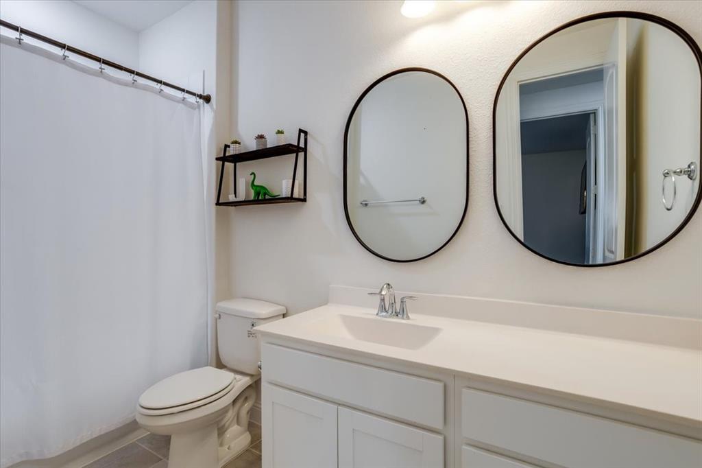 Full bathroom featuring vanity, a shower with shower curtain, and light tile patterned flooring