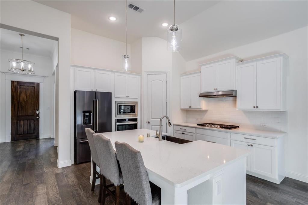 Custom painted cabinetry with shaker style doors and stainless hardware.
