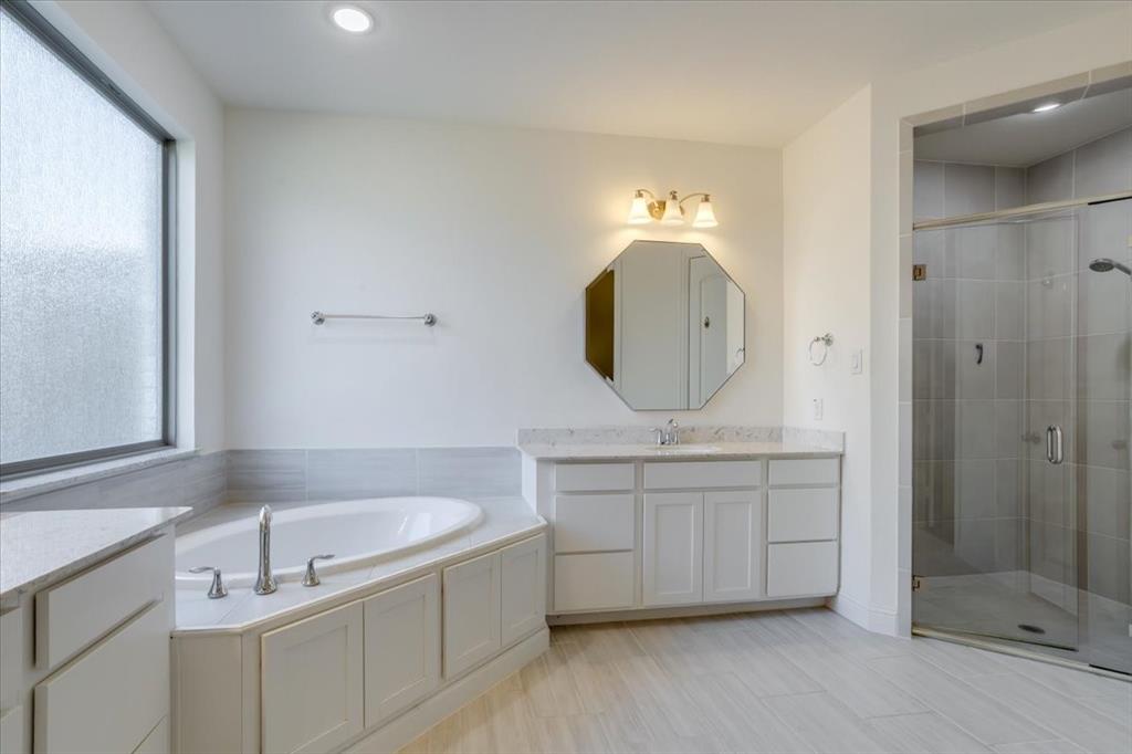 Primary Bathrooms- clean and classic from the rectangular tiled floors to the painted cabinetry and quartz countertops.