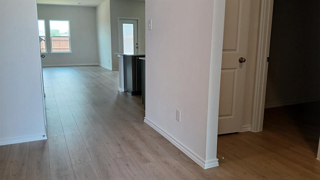 Light wood-finish flooring throughout, complemented by white baseboards and neutral wall tones