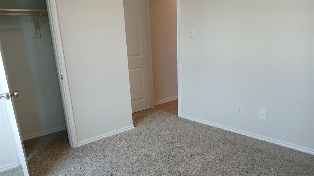 Light beige wall-to-wall carpeting throughout this space, featuring white baseboards and trim