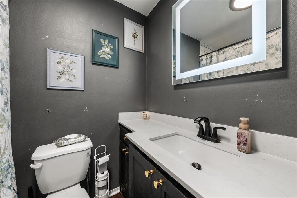 Full bathroom featuring a shower with curtain, vanity, and a textured wall