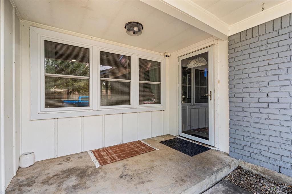 Entrance to property featuring brick siding, a patio area, and board and batten siding Entrance to property featuring brick siding, a patio area, and board and batten siding