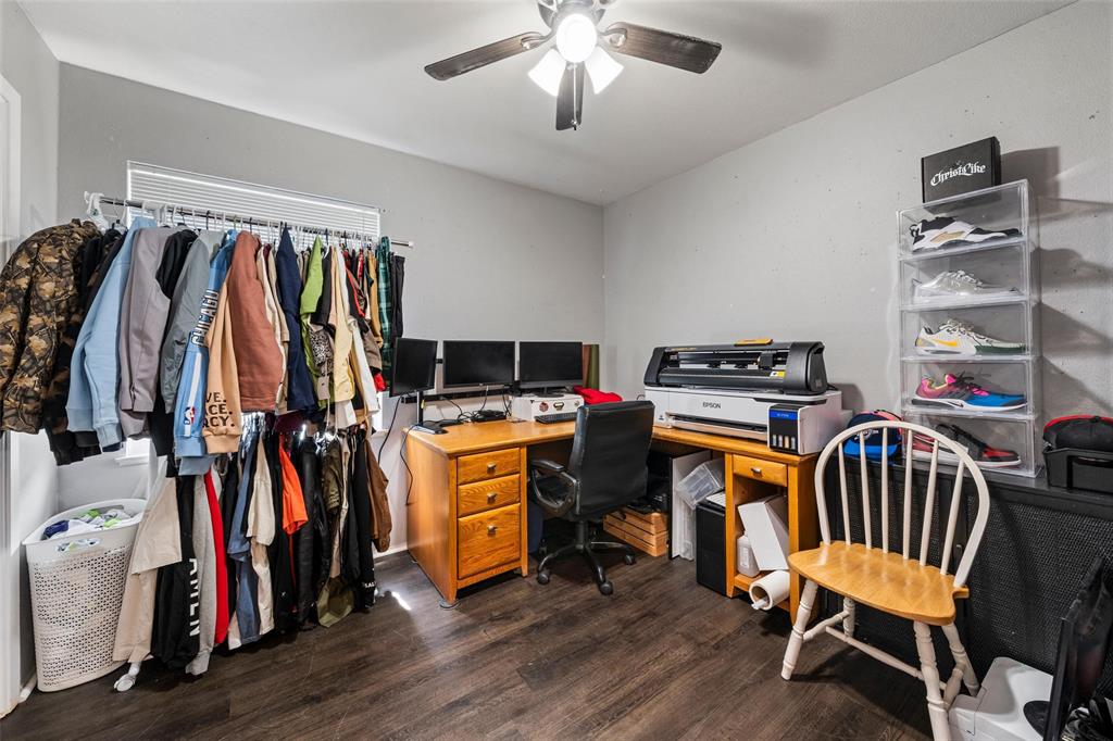 Office space with dark wood-style floors and ceiling fan