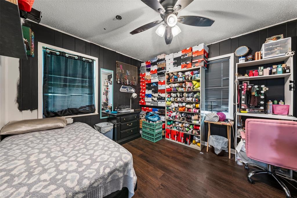 Bedroom featuring a textured ceiling, dark wood-type flooring, and ceiling fan