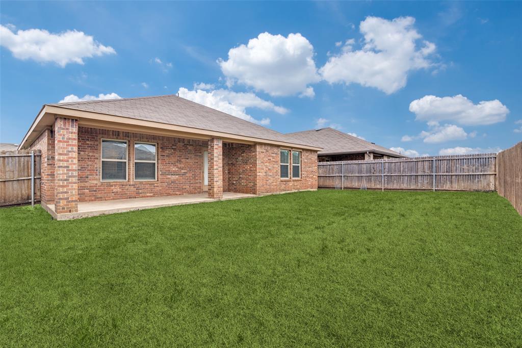 Covered patio and fenced in backyard