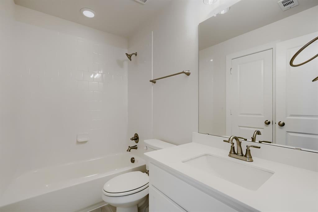 Bathroom featuring a vanity with an integrated sink, brushed nickel faucet, and a large mirror