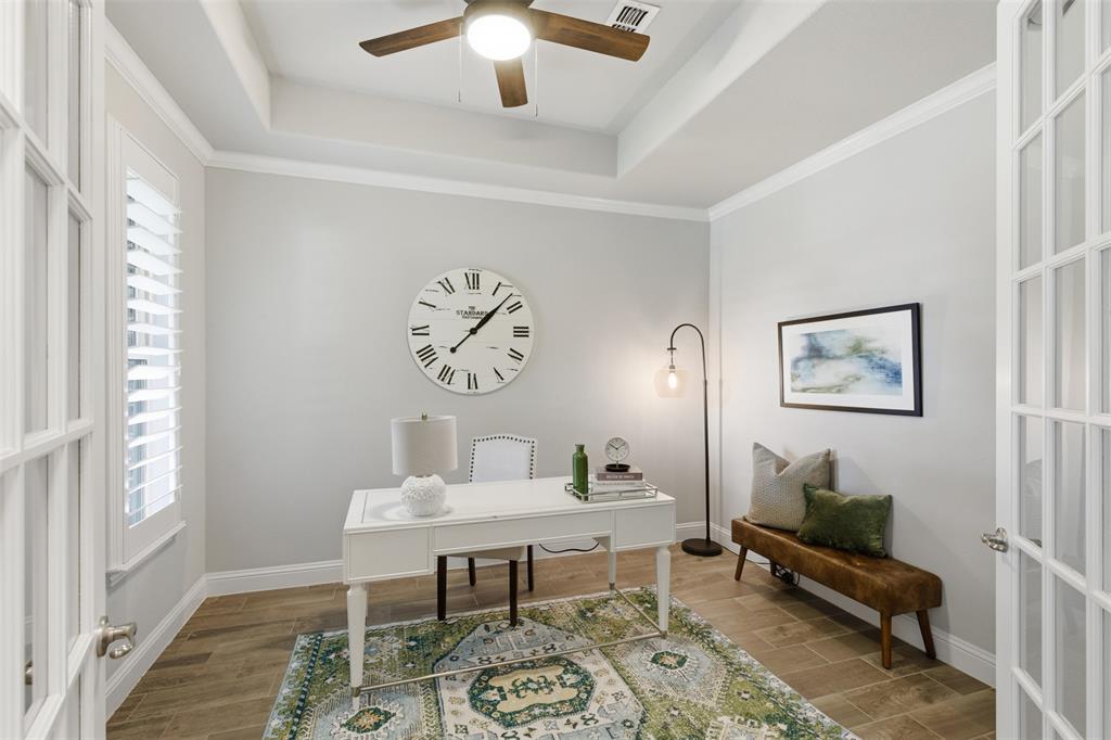 Room with wood-finish flooring, white walls, and a tray ceiling