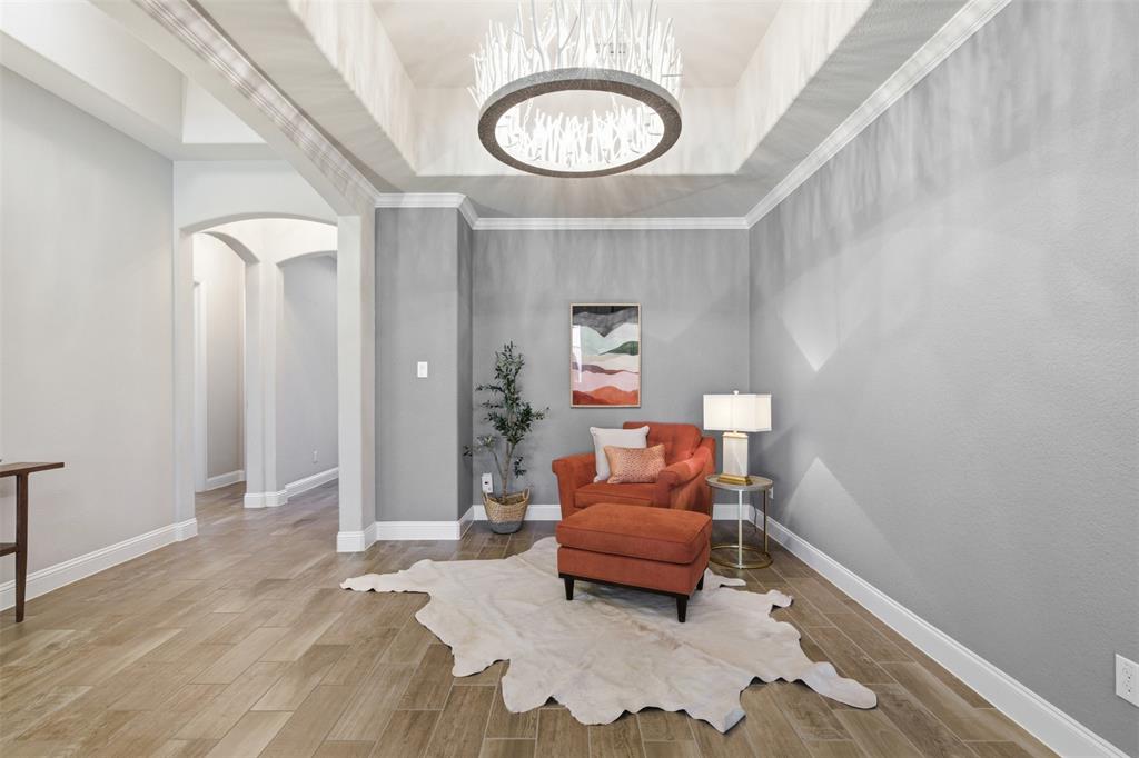 Tray ceiling featuring a unique chandelier in the formal dining room