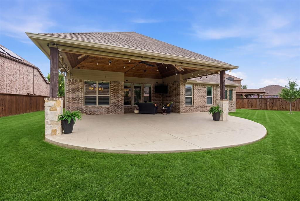 The spacious tiled patio overlooks a large, beautifully maintained backyard—perfect for relaxing evenings or hosting guests in style.