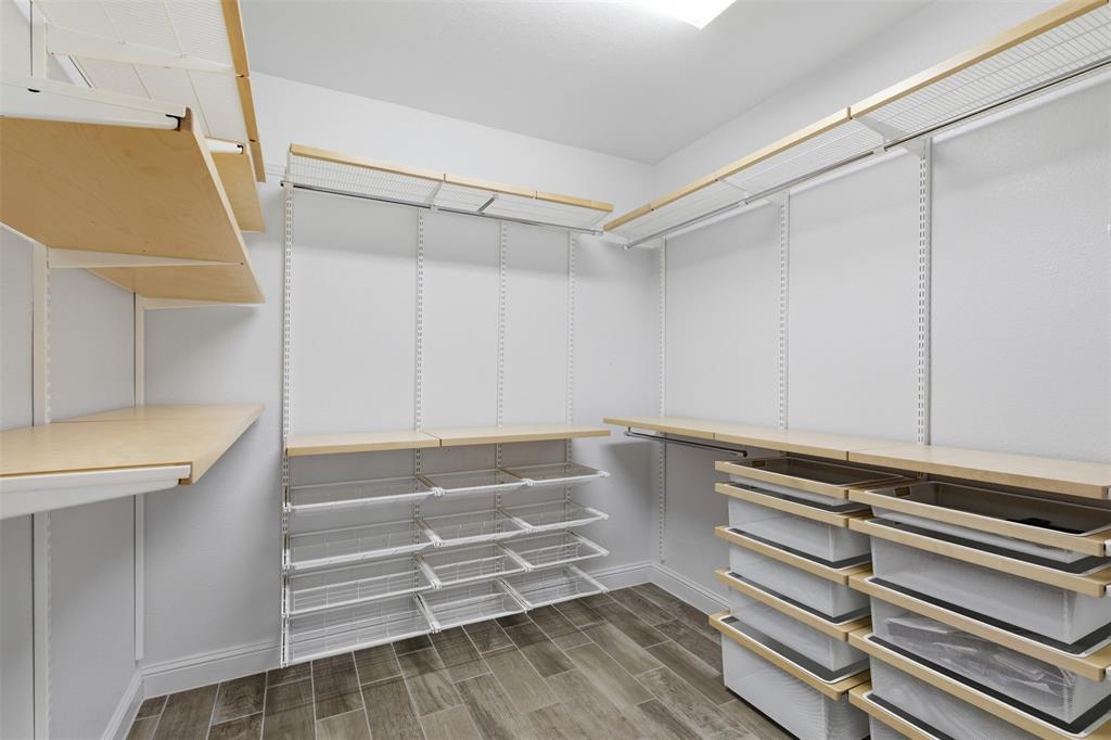 Walk-in closet featuring wood-finish shelving and wire baskets, wire rack storage, wood-finish flooring, and recessed lighting