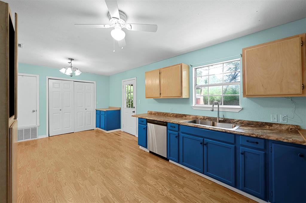 Kitchen with hanging light fixtures, dishwasher, sink, light hardwood / wood-style floors, and light brown cabinets