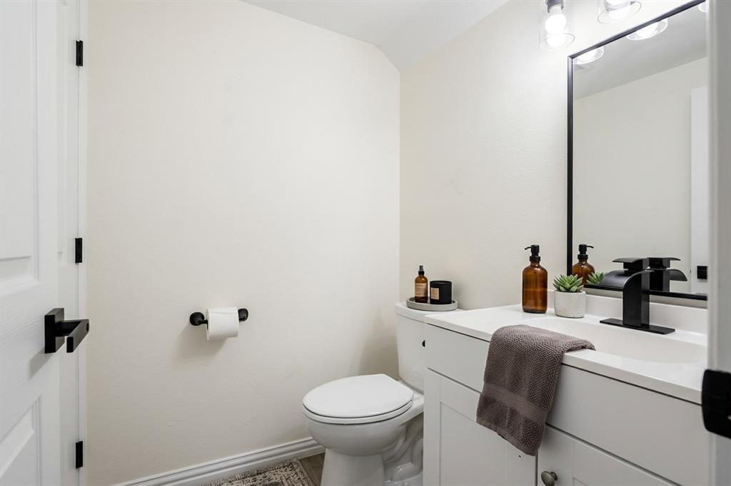 White vanity with integrated sink, black rectangular framed mirror, matte black faucet, and coordinating black hardware