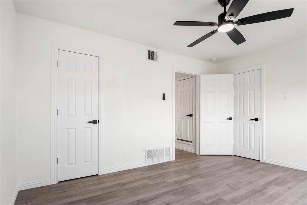 Room with wood-finish flooring, white painted walls, and white baseboards